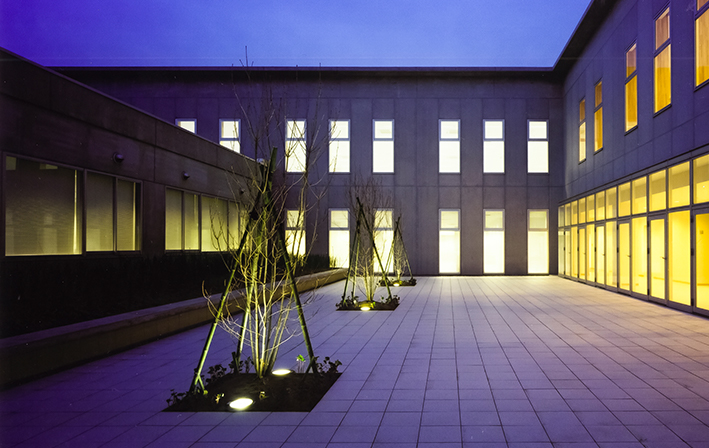 屋内からの灯りに包まれた、夕方の中庭。